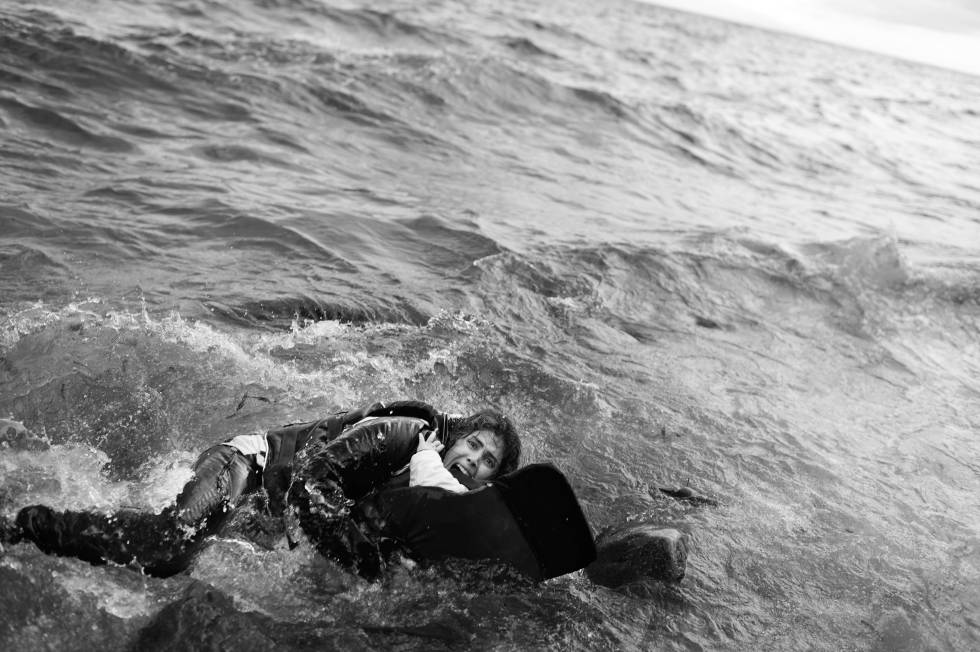 Foto de Samuel Aranda, 'Llegando al paraíso' Una madre abrazada a su hijo en el agua en la costa de Lesbos. Premio 2016.