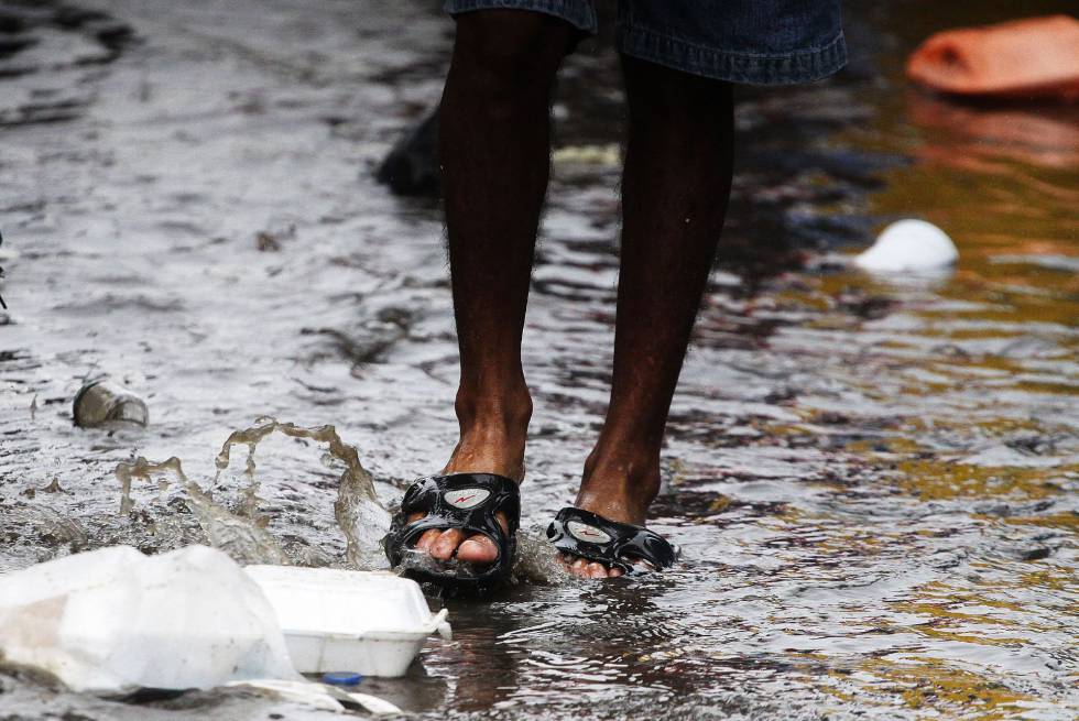 Integrantes de la caravana de migrantes centroamericanos tratan de protegerse tras la inundaciÃ³n de un albergue en Tijuana (MÃ©xico). 