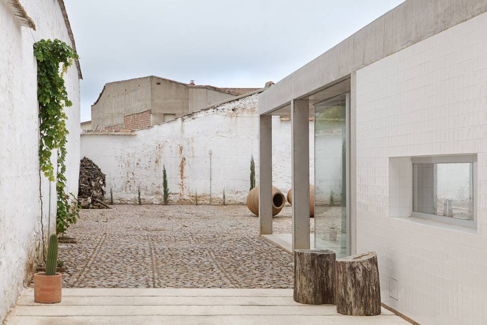 Una vez en el patio empedrado, por el que se llega al traspasar la puerta metálica que da a la calle,  dos troncos marcan el acceso lateral a la vivienda.