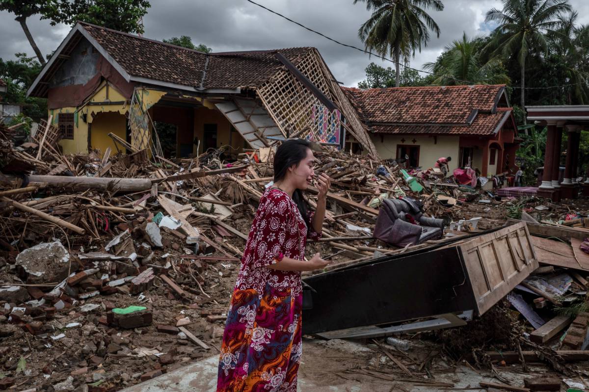 Una mujer llora ante las casas destruidas por el tsunami.