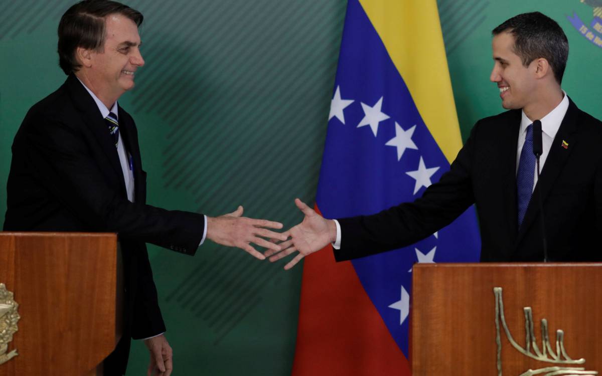 Bolsonaro y Guaidó se estrechan la mano este jueves en Brasilia.