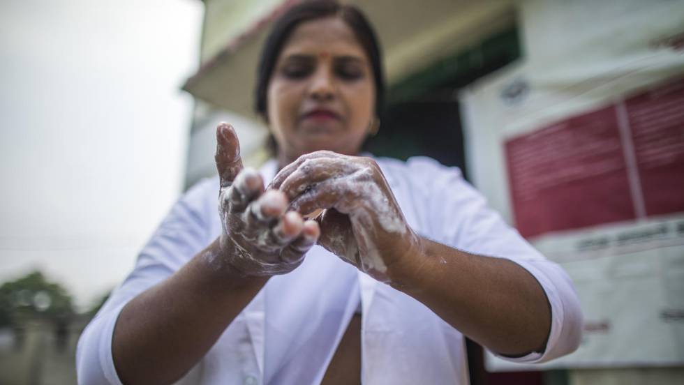 Una enfermera se lava las manos en un ambulatorio en India antes de atender a una embarazada.