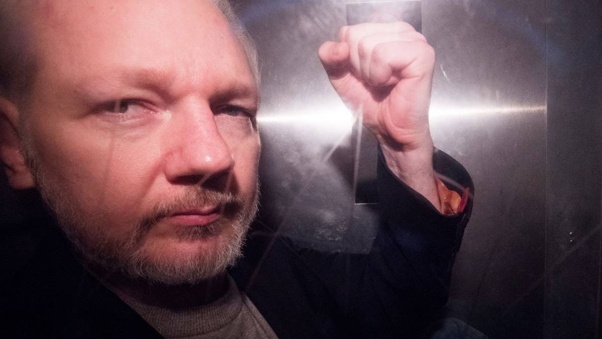 Julian Assange saluda desde un vehículo policial, en Londres.