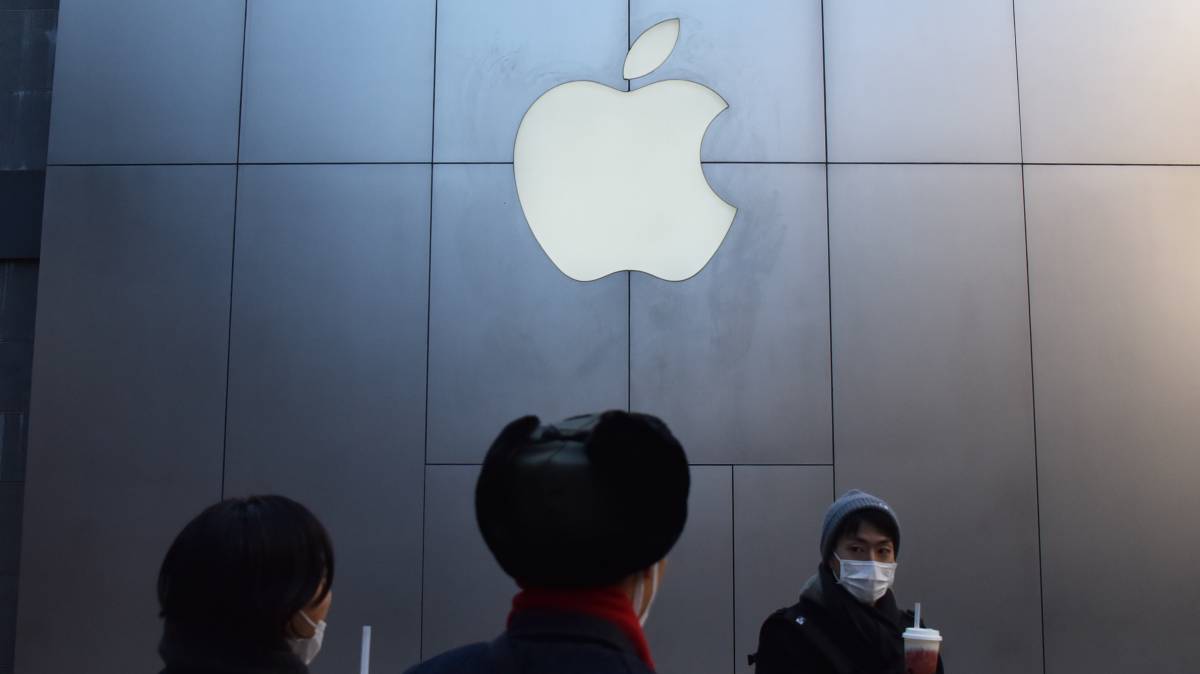 Un grupo de personas pasa delante de una tienda de Apple en Pekín.