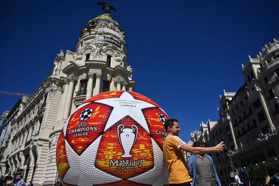 A passerby takes a selfie with a giant replica of the UEFA Champions League ball displayed in Madrid on May 29, 2019 ahead of the final football match between Liverpool and Tottenham Hotspur on June 1. (Photo by GABRIEL BOUYS AFP)