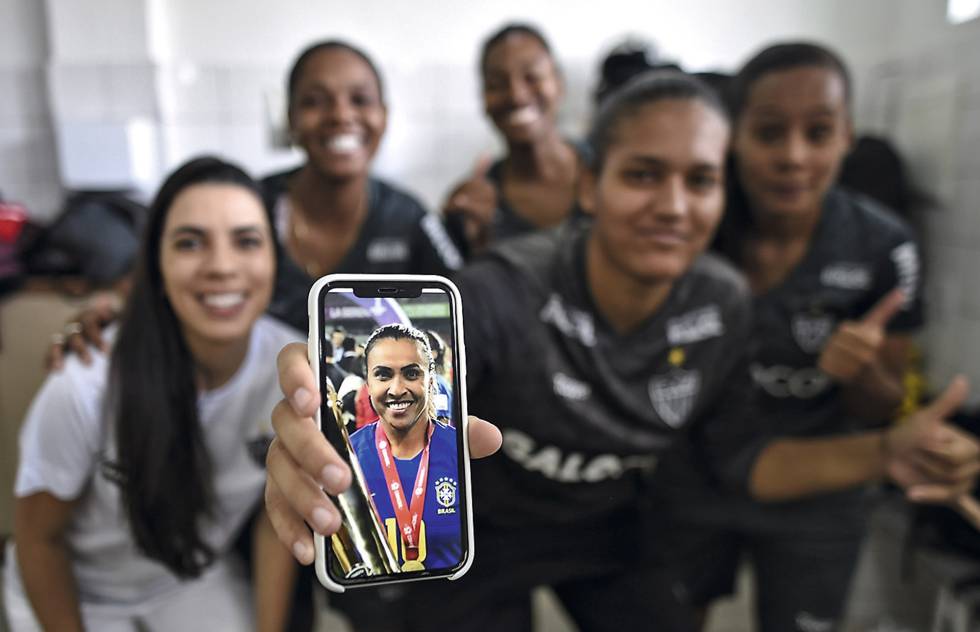 The Atlético MG players show a photo of Marta Vieira.