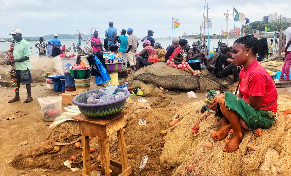 En el puerto de Conakry, la comida y bebida se venden junto al muelle. Muchos pescadores optan por vivir en sus barcos en vez de en casas.