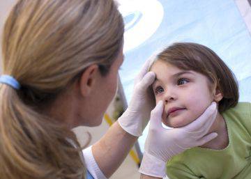An ophthalmologist checks the eyes of a child.