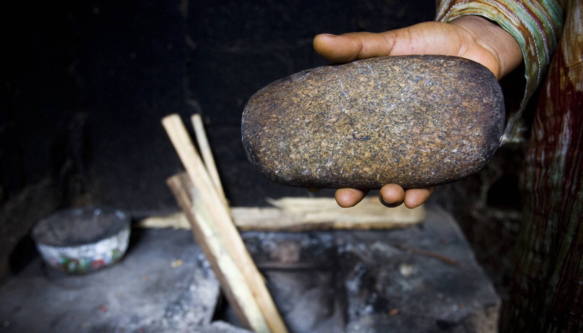Philomena, de 39 años, usó esta piedra calentada al horno para planchar los pechos de sus hijas. Imagen tomada en Yaundé, Camerún, en 2007.
