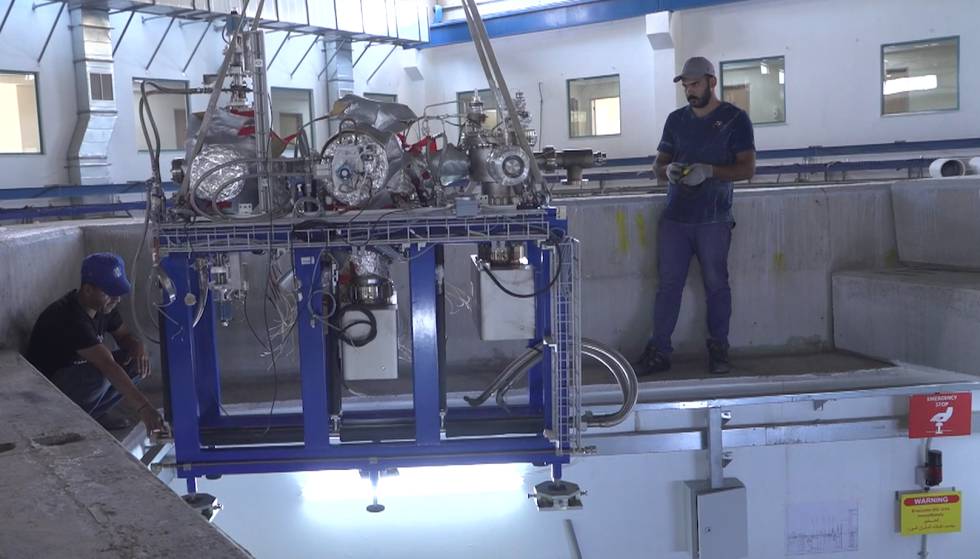 Dos trabajadores, en las instalaciones jordanas de SESAME, una instalación que genera rayos de luz muy intensos para el análisis de componentes.