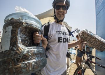 Un activista muestra las miles de colillas que ha recogido en la playa de la Barceloneta.