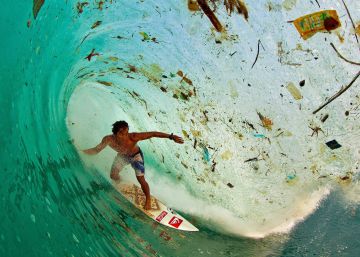 Un surfista en el medio de una ola llena de residuos. 