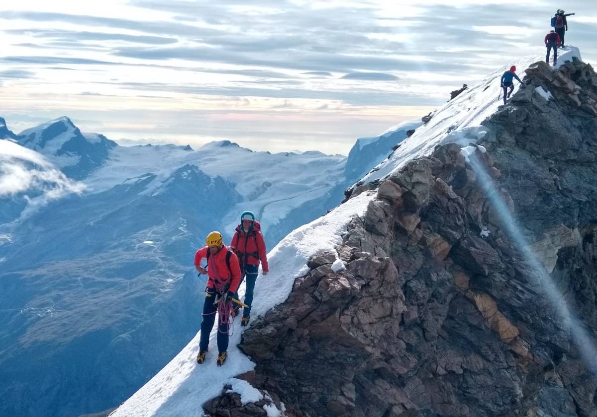 El guía argentino Tomi Aguiló y su clienta Ángela recorren el camino entre la cima suiza y la italiana.