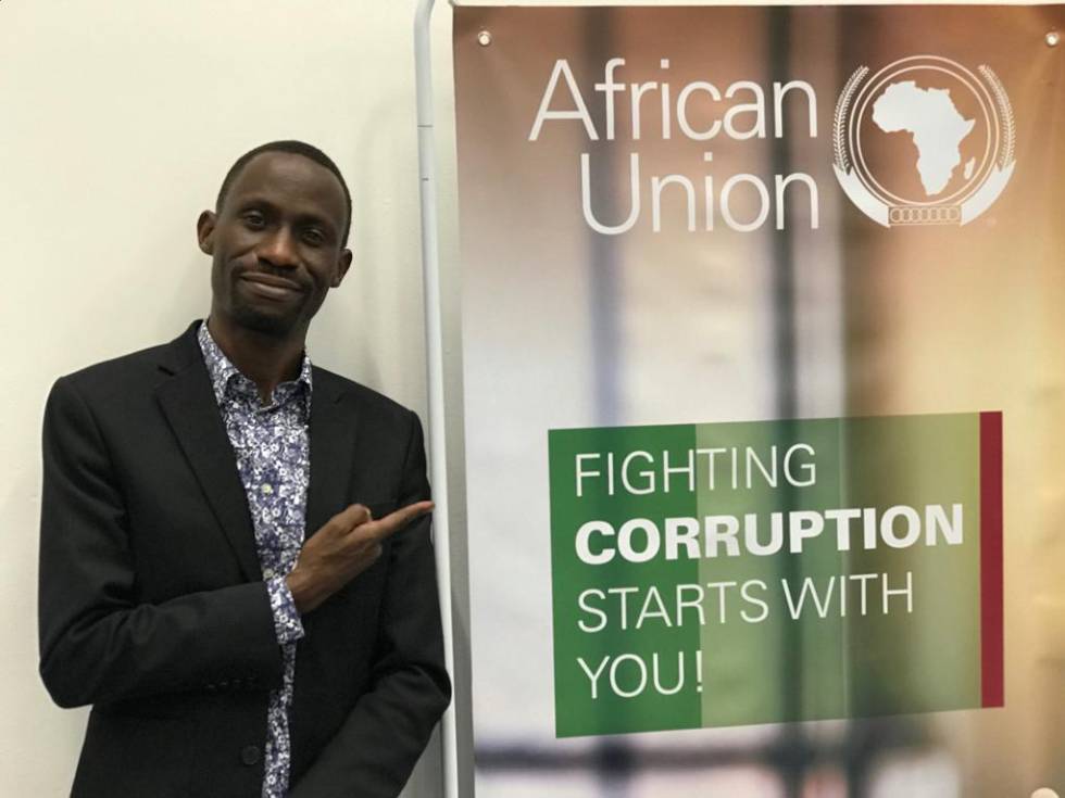 Maxence M. Melo, uno de los fundadores de la plataforma Jamii Forums, ante un cartel de la UniÃ³n Africana que alienta la lucha contra la corrupciÃ³n.