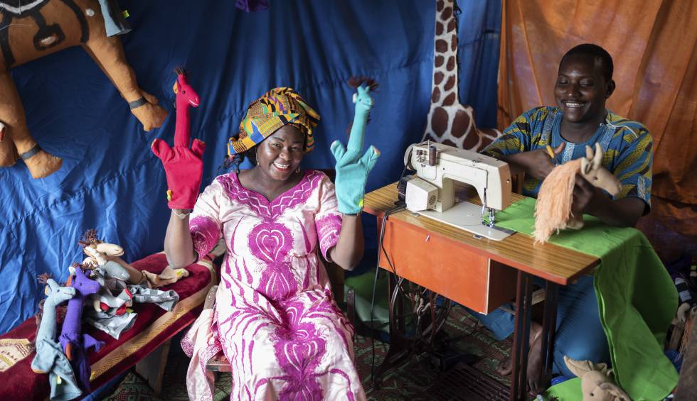 Rosine Kiema muestra las marionetas de la marca BiiBop junto a uno de los costureros que las fabrica.