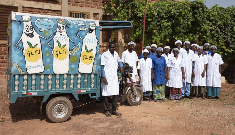 La empresaria Esther Dienderé y el equipo de producción de los zumos Glou junto a un camión de reparto. 