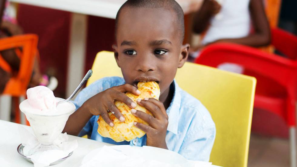 Un niño desayunando un bollo en Costa de Marfil.