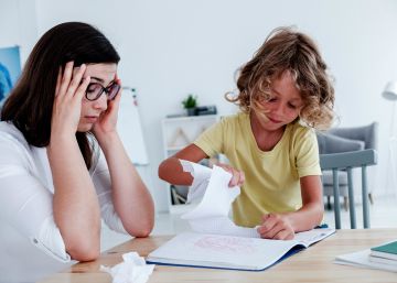 Un niño rompe una página de un cuaderno. 