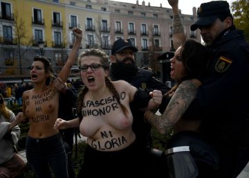 Dos agentes intentan frenar la protesta de las integrantes de Femen.
