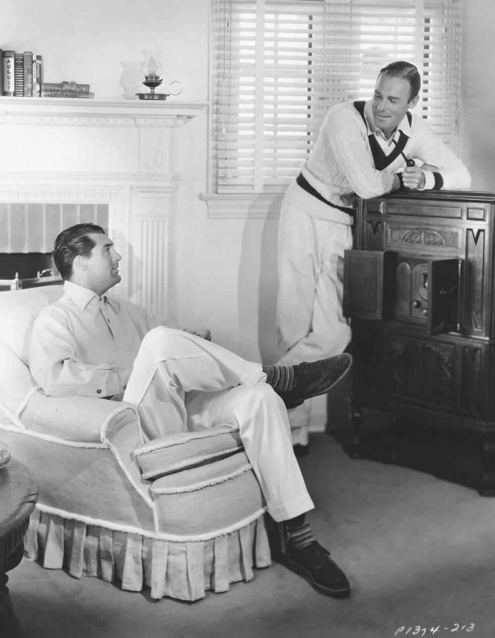 Cary Grant, sentado, y Randolph Scott posan en el salón de la casa que compartieron durante 12 años en Santa Mónica.