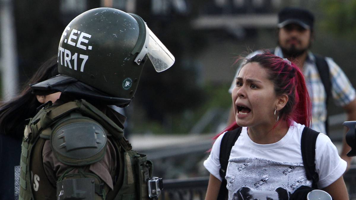 Una mujer discute con un carabinero en Chile.