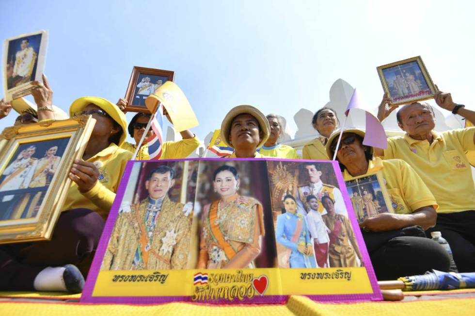 Varios ciudadanos posan con retratos del rey Rama X y la reina Suthida de Tailandia en la ceremonia de coronación.rn