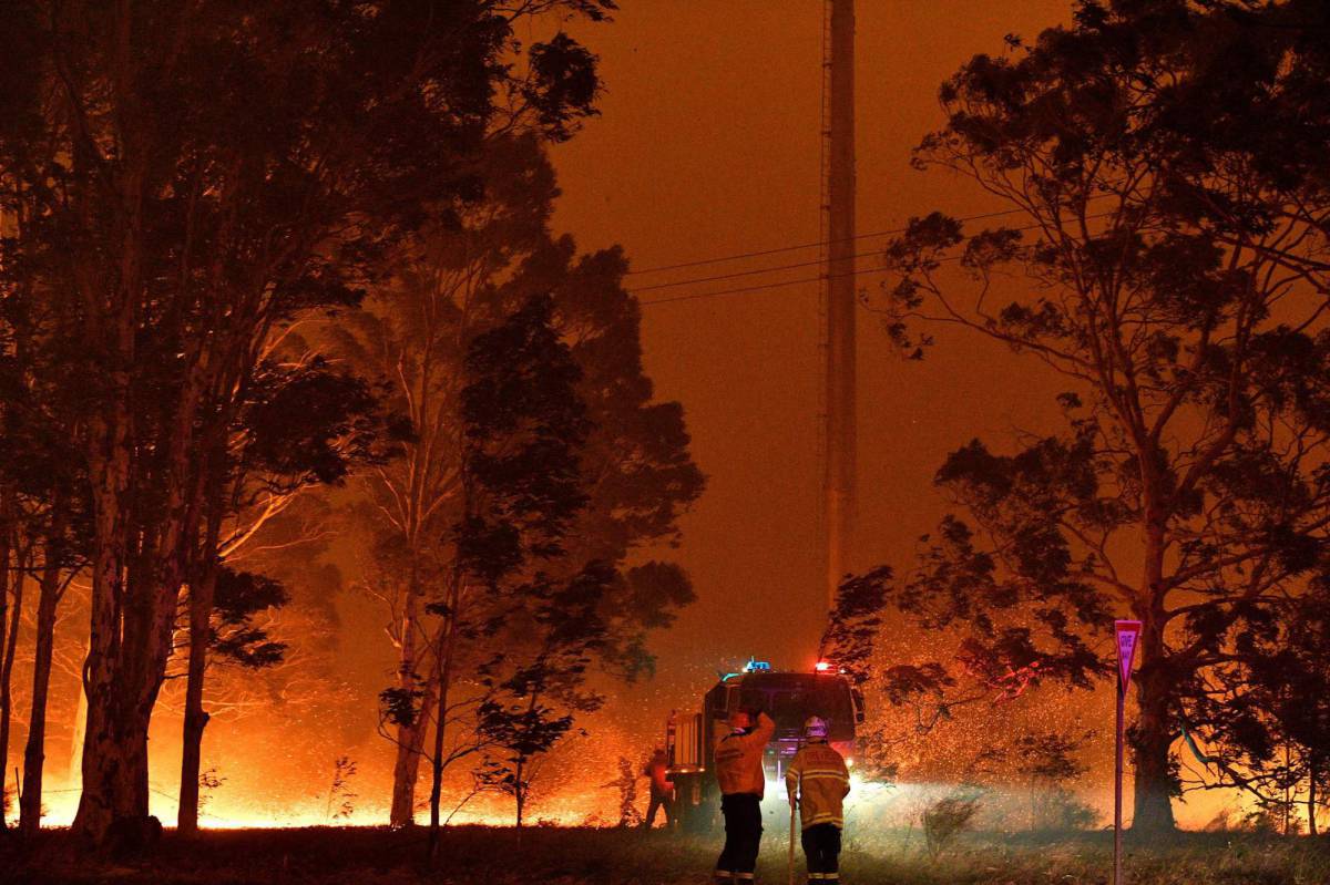 Los bomberos tratan de extinguir un incendio en Nowra (Australia), este martes.