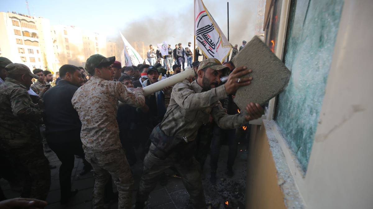 Un grupo de manifestantes intenta romper un cristal blindado de la embajada estadounidense en Bagdad (Irak), el 31 de diciembre.