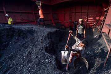 Unos trabajadores descargan carbón en Gabtoli, Bangladesh.