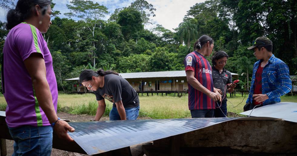 Los jóvenes achuar trabajan en un nuevo panel solar.