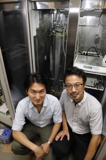 Hiroyuki Imachi (derecha) y su compañero Masaru Nobu, autores del estudio, posando junto al biorreactor que usaron para criar las arqueas.