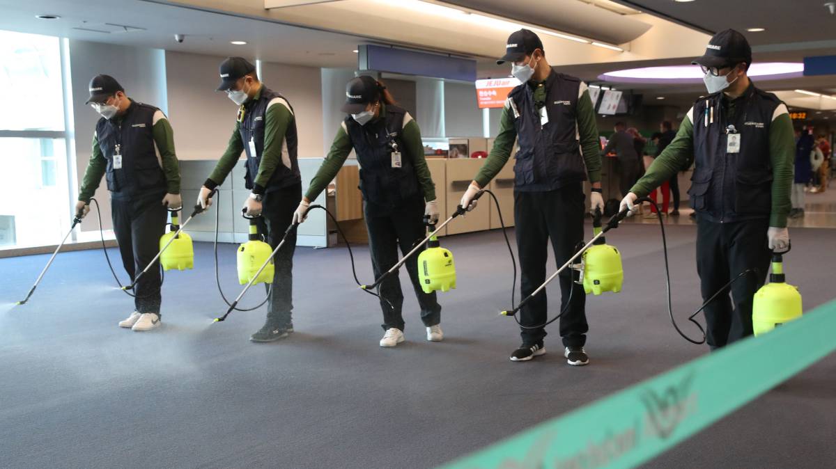 Operarios desinfectan el área de aduanas del aeropuerto internacional de Incheon (Corea del Sur).