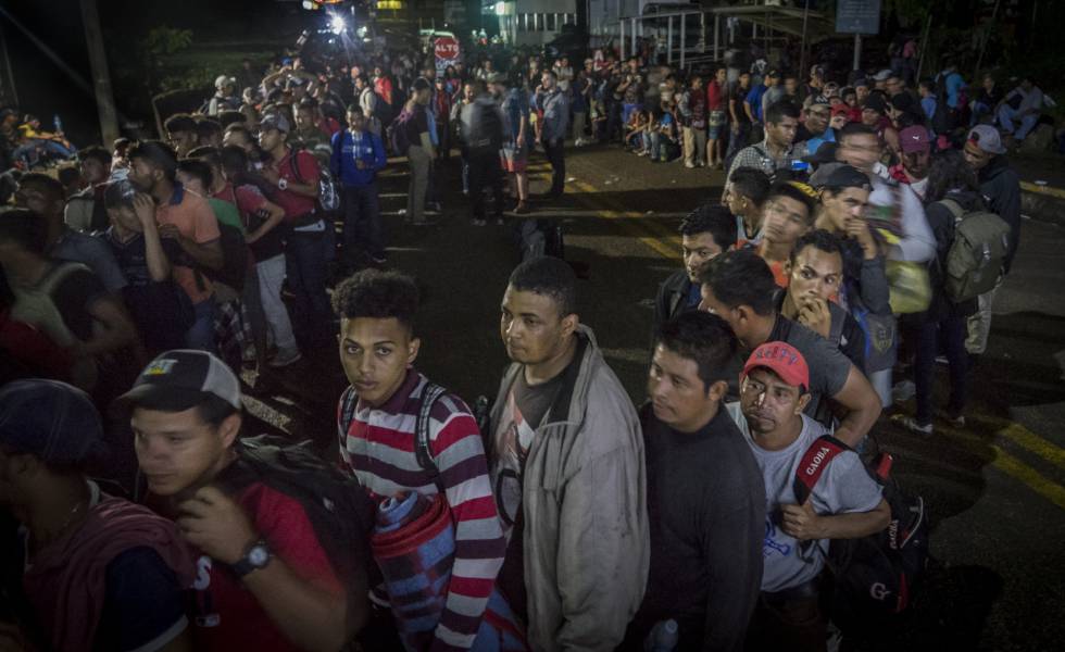 Centroamericanos de la caravana migrante esperan en fila para acceder al puesto fronterizo de El Ceibo, Tabasco (México).