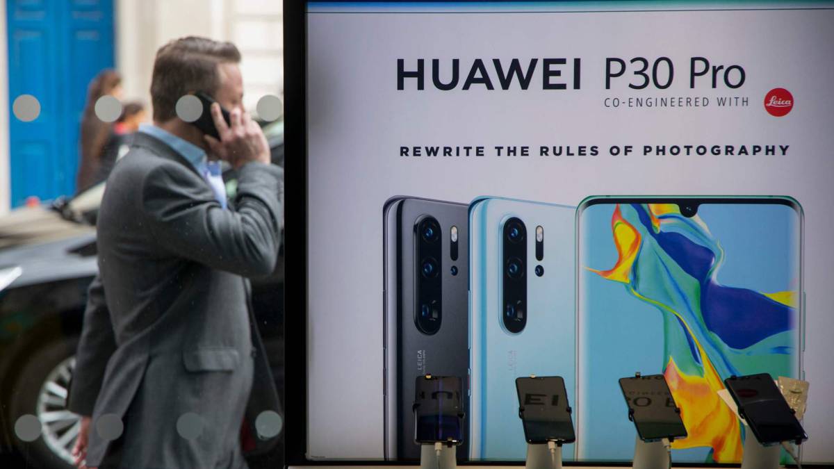 Un hombre pasa ante un cartel de Huawei en Londres.