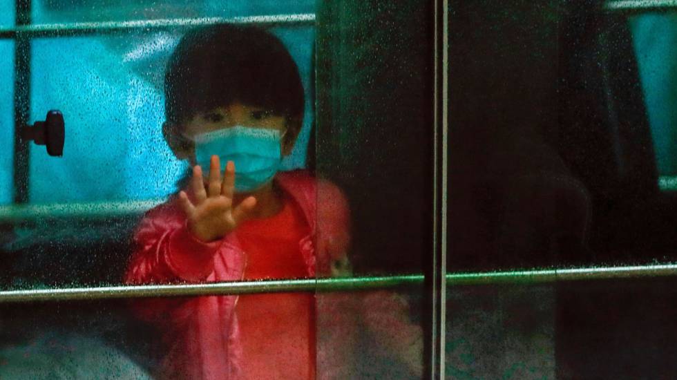 Una niña en un vehículo que transporta a los residentes evacuados de un edificio de viviendas públicas de las afueras de Hong Kong, el pasado 11 de febrero. rn rn rn