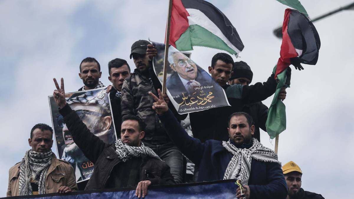 Manfiestantes palestinos con carteles de Abbas.