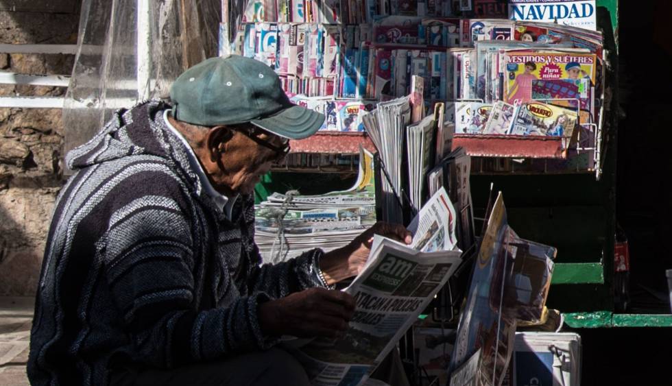 Un hombre lee un periódico en Guanajuato. 