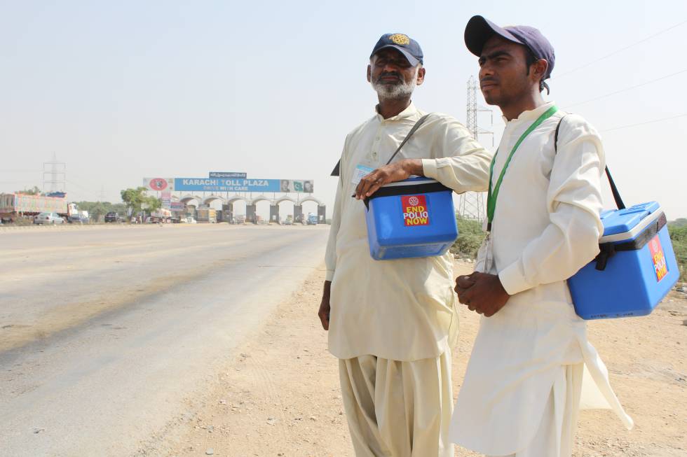 Dos colaboradores de la campaña de vacunación junto al peaje de Karachi. También los niños que viajan en los autobuses de paso tienen que someterse a los controles para detectar el virus de la poliomielitis.