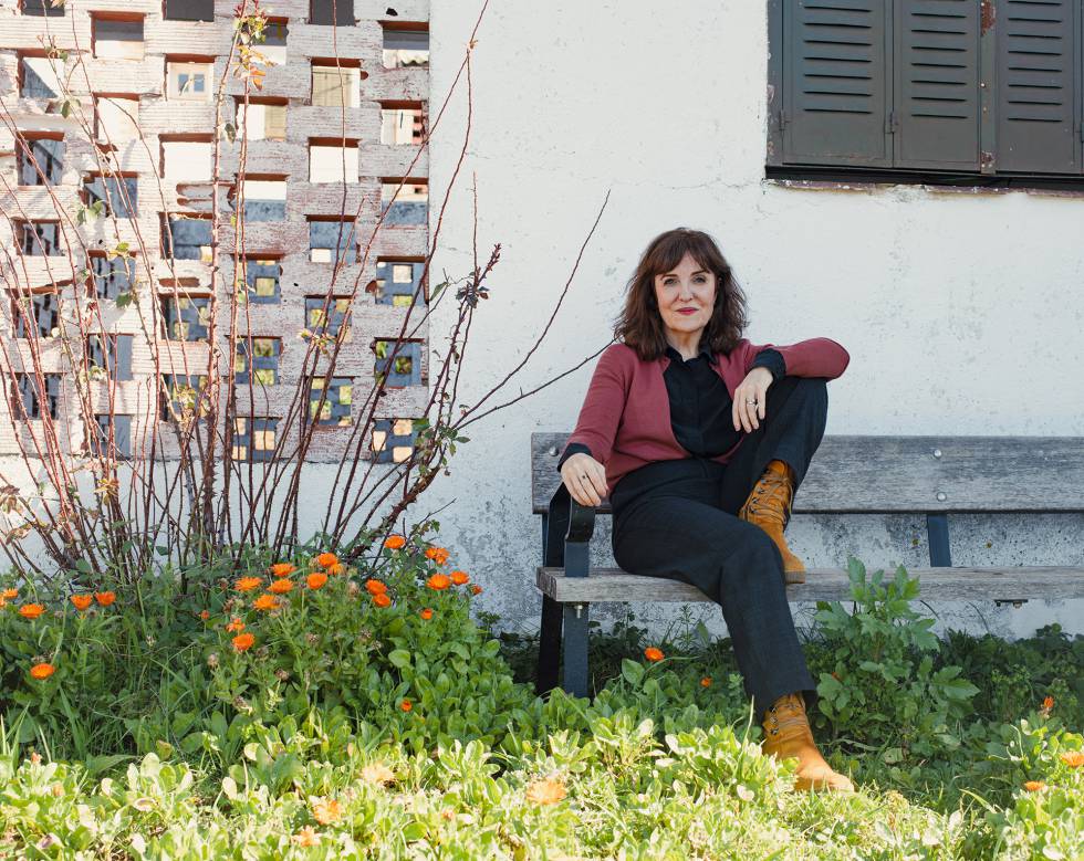 La escritora, junto a uno de los edificios del poblado de El Atazar, donde transcurre parte de su nueva novela, 'A corazón abierto'.