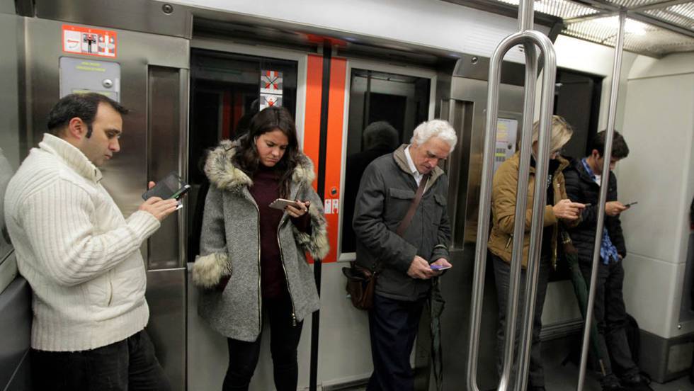 Viajeros del Metro de Bilbao consultan sus móviles.