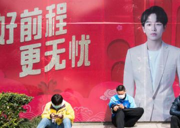 Cuatro repartidores con mascarillas junto a una boca de metro en Shangai, el mes pasado.