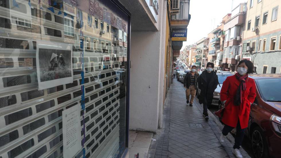 Viandantes de origen chino se protegen con mascarillas en el distrito madrileño de Usera.