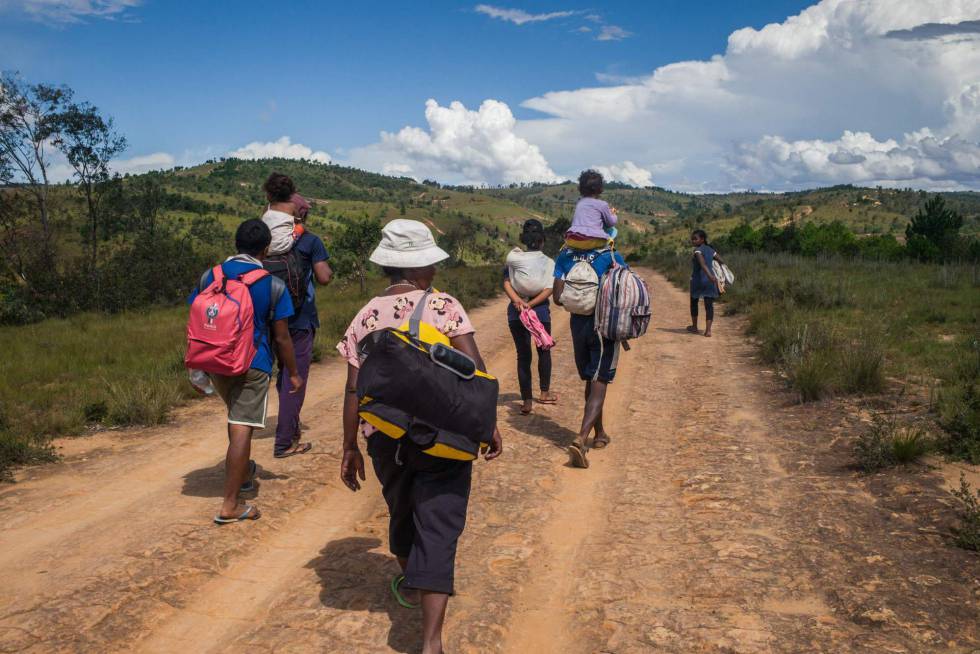 Varios residentes de Antananarivo caminan por la carretera nacional 7 que conduce al sur de Madagascar el pasado 27 de marzo de 2020. Han decidido abandonar la capital para regresar a su lugar de nacimiento por temor a la pandemia o porque han perdido sus empleos como resultado del cierre de la ciudad ordenado por las autoridades desde el 23 de marzo de 2020
