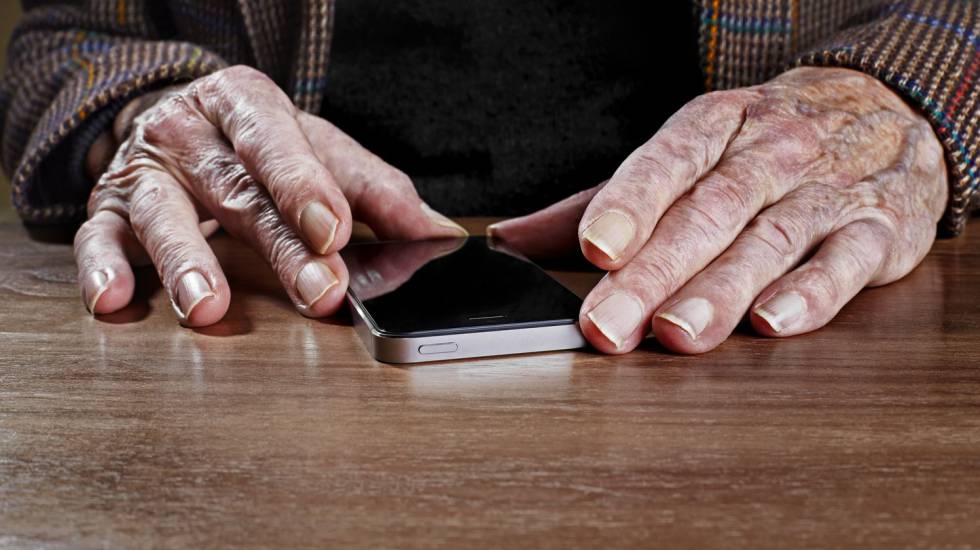 Un hombre mayor sostiene un 'smartphone'.