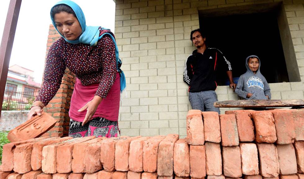 Rabindra (centro) and Anjana Tajale (izquierda) trabajan en la construcción de su nueva vivienda en Bhaktapur, Nepal, el 21 de abril de 2020. El terremoto que asoló el país en abril de 2015 les dejó sin casa y han vivido como desplazados internos hasta ahora.