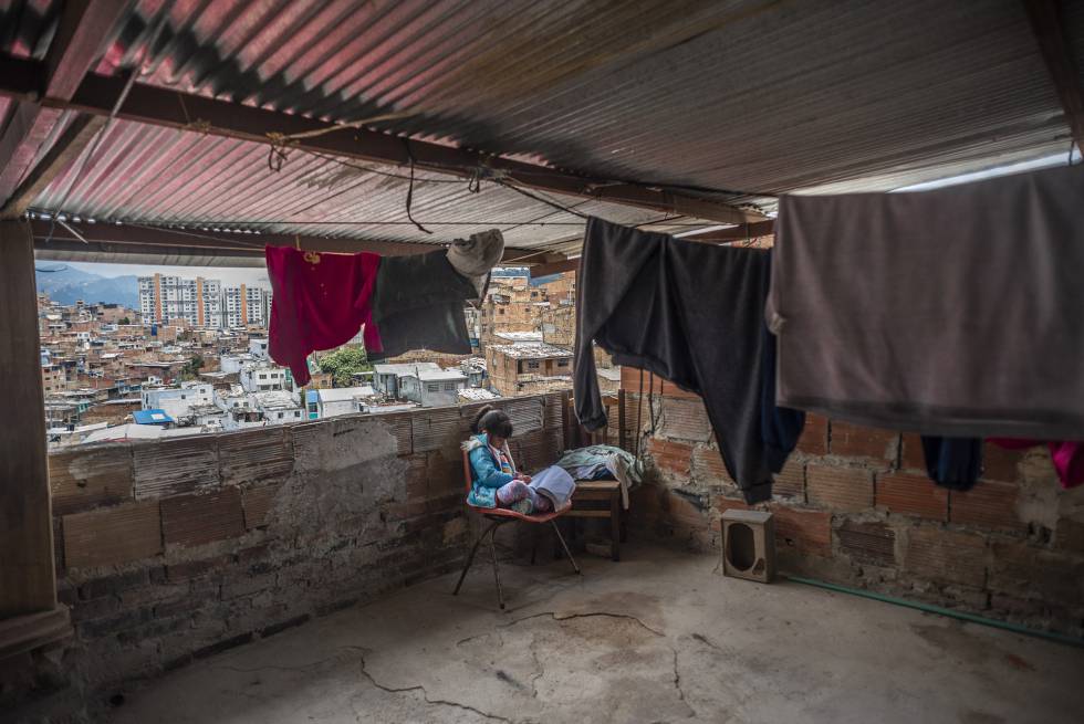 Una niña del cabildo Kubeo estudia sola en una terraza en el barrio El Pesebre de Bogotá.