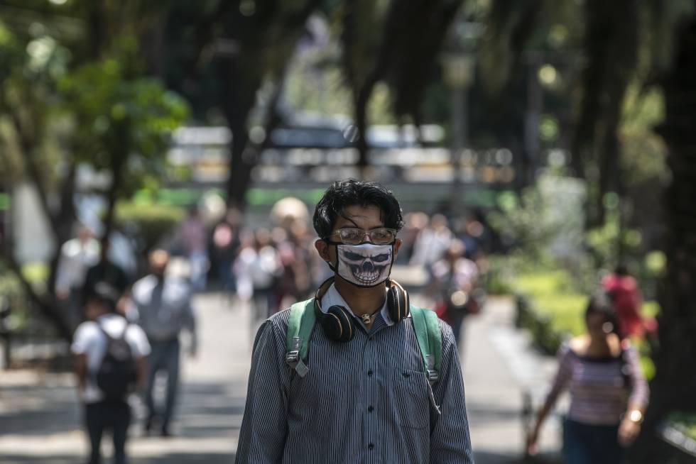 Un joven estudiante con mascarilla camina por la calle Génova, en Ciudad de México.