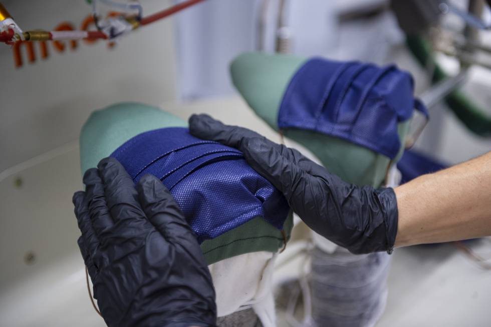 Una trabajadora de la Sociedad Textil Lonia, fabricante de las marcas Purificación García y Carolina Herrera, en Pereiro de Aguiar (Ourense), realiza el planchado de una mascarilla.