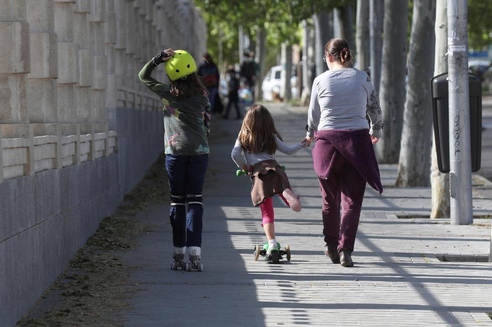 Adultos pasean a niños en el Parque Santander de Madrid.
