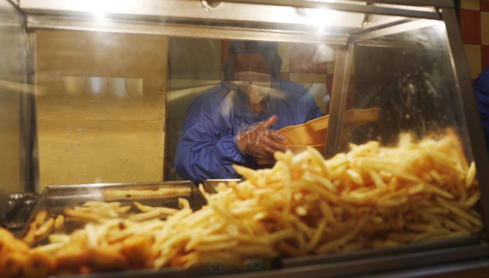 Un empleado de un restaurante de comida rápida de La Paz (Bolivia) coge patatas fritas.